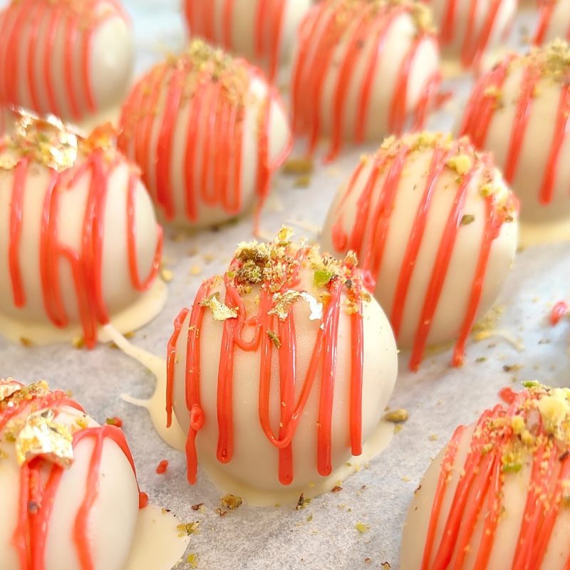 Fresas bañadas en chocolate blanco y rojo, especialidad en tartas personalizadas en Sevilla.